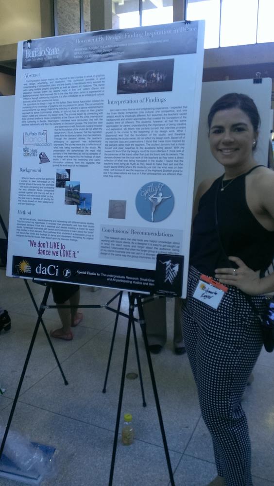 A young female stands next to her poster presentation.