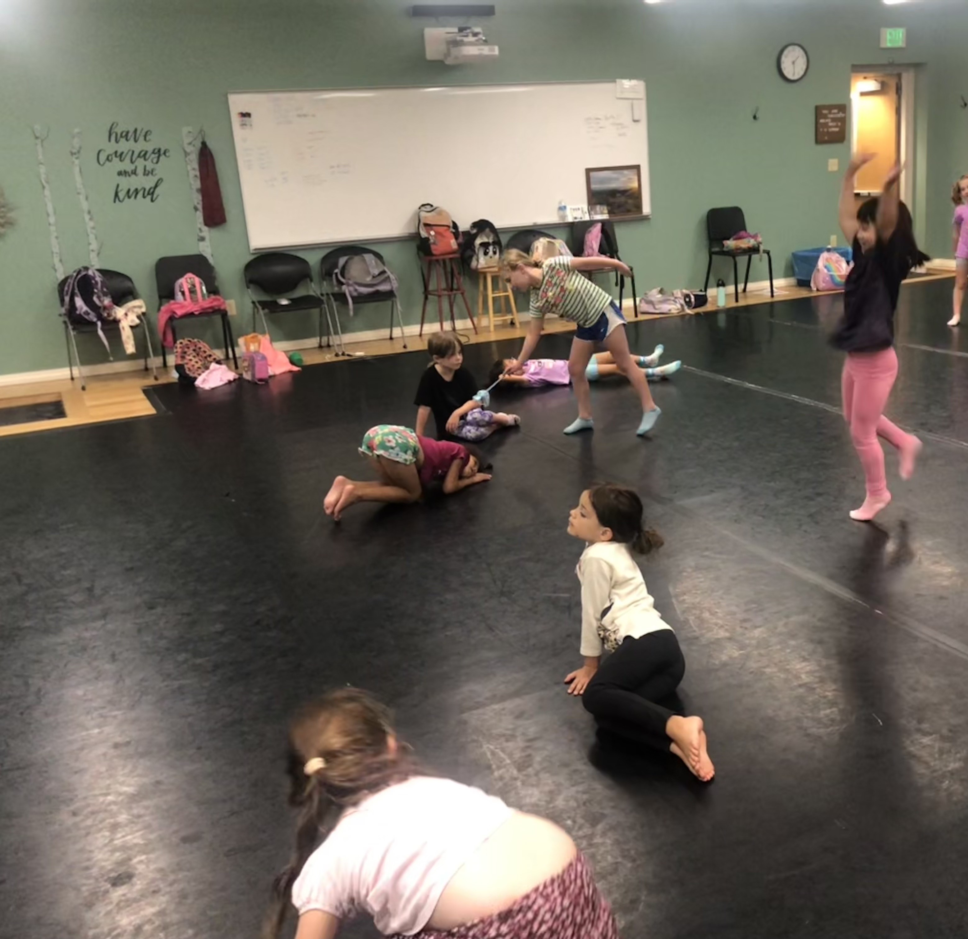 Young students in a dance class all in different shapes.