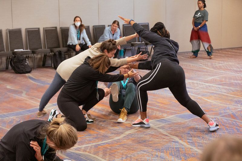 dance educators connect to each other with their arms at the 2023 national conference